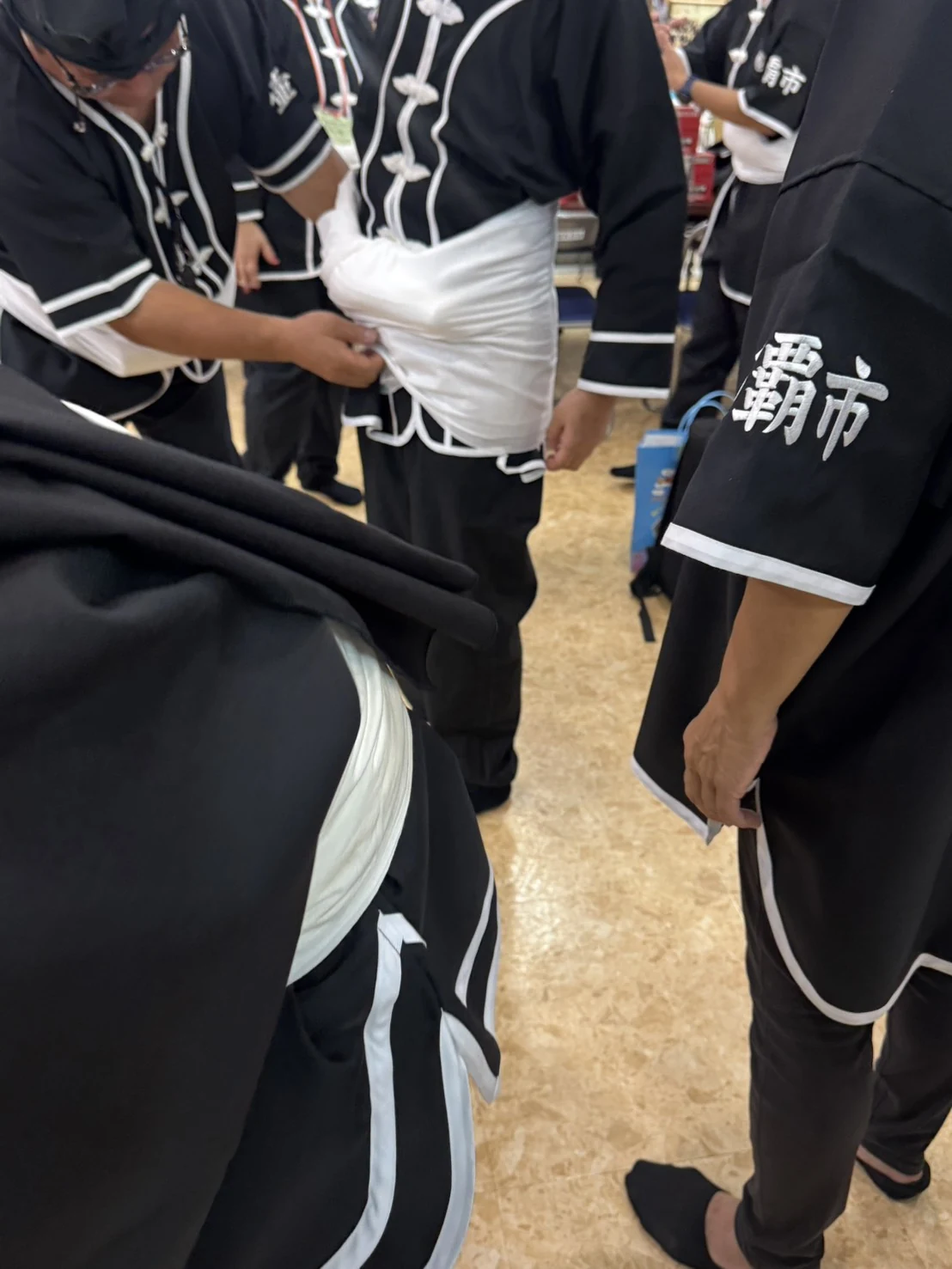 那覇大綱挽の黒い衣装に白い帯を巻く参加者
