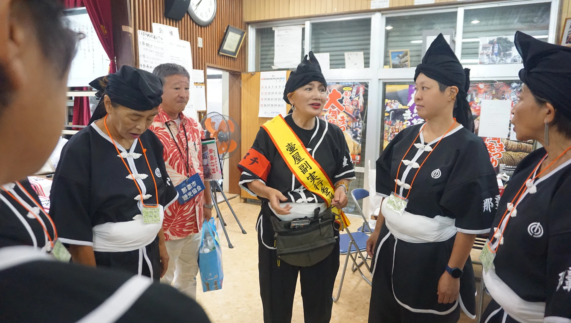 壺屋旗頭華鳳会の参加者が衣装を整えながら言葉を交わす様子