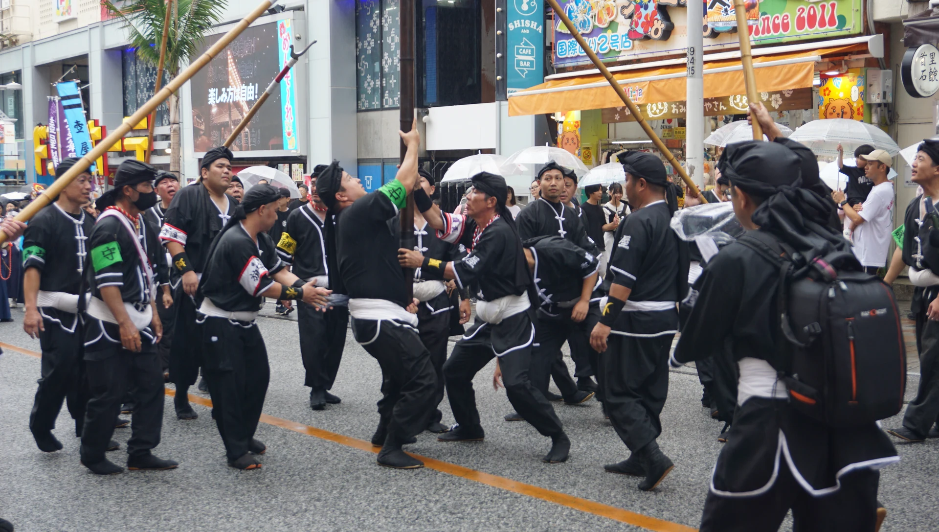 旗竿を支える旗持ちと、その周囲に集まる壺屋旗頭華鳳会の人たち