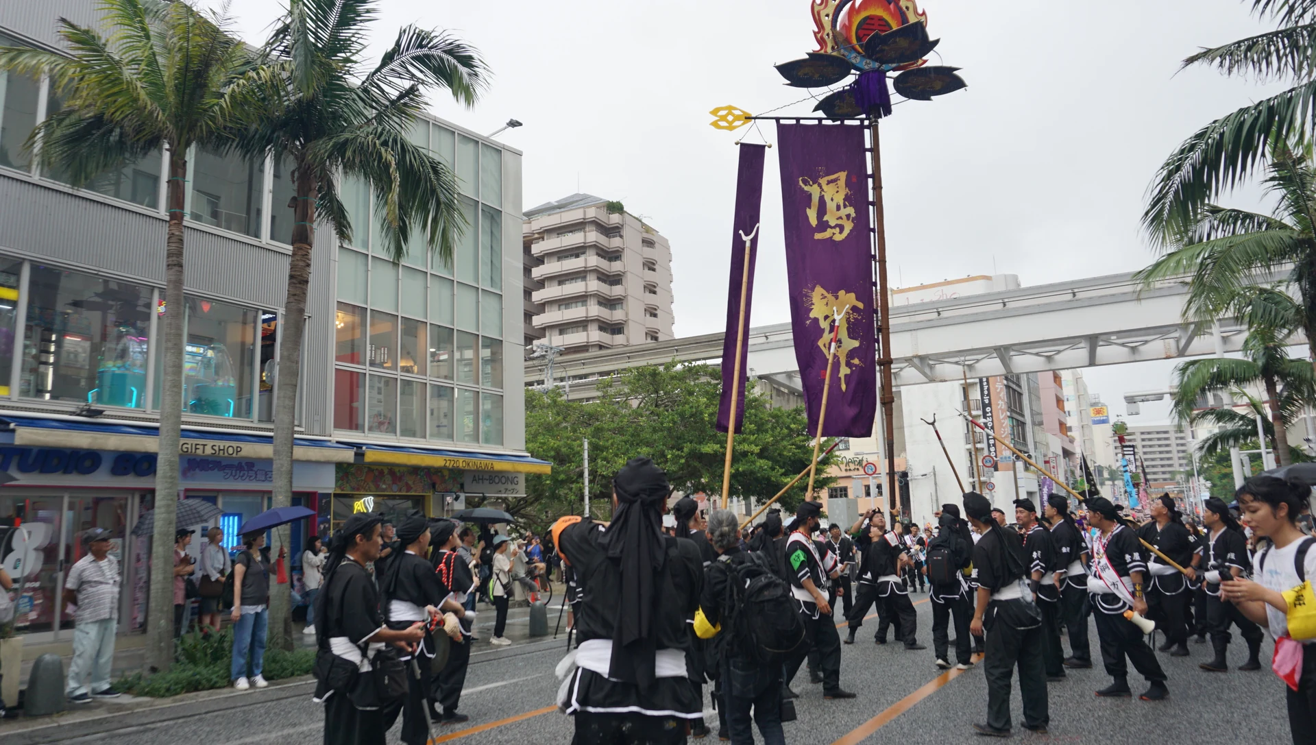 国際通りで旗頭を掲げる壺屋旗頭華鳳会の一行