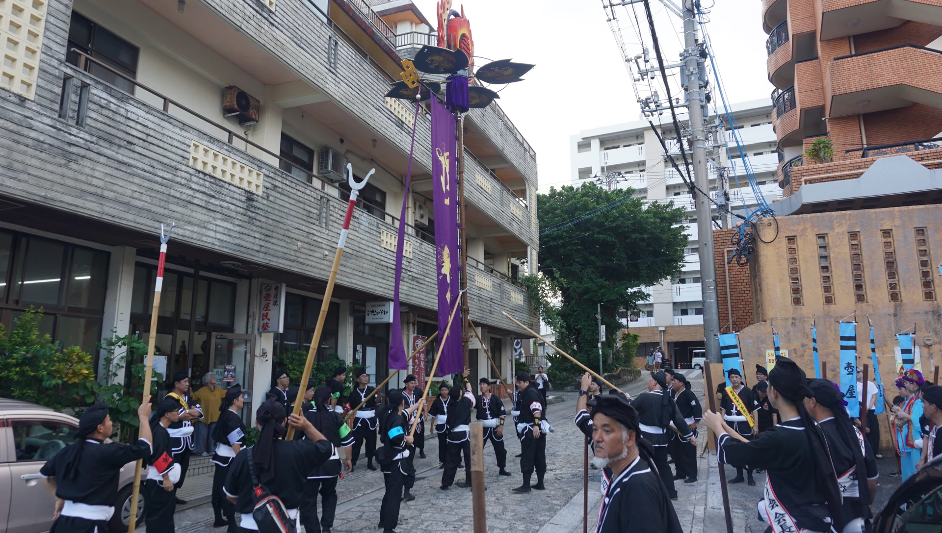 壺屋の住宅街を進む旗頭と行列の参加者たち