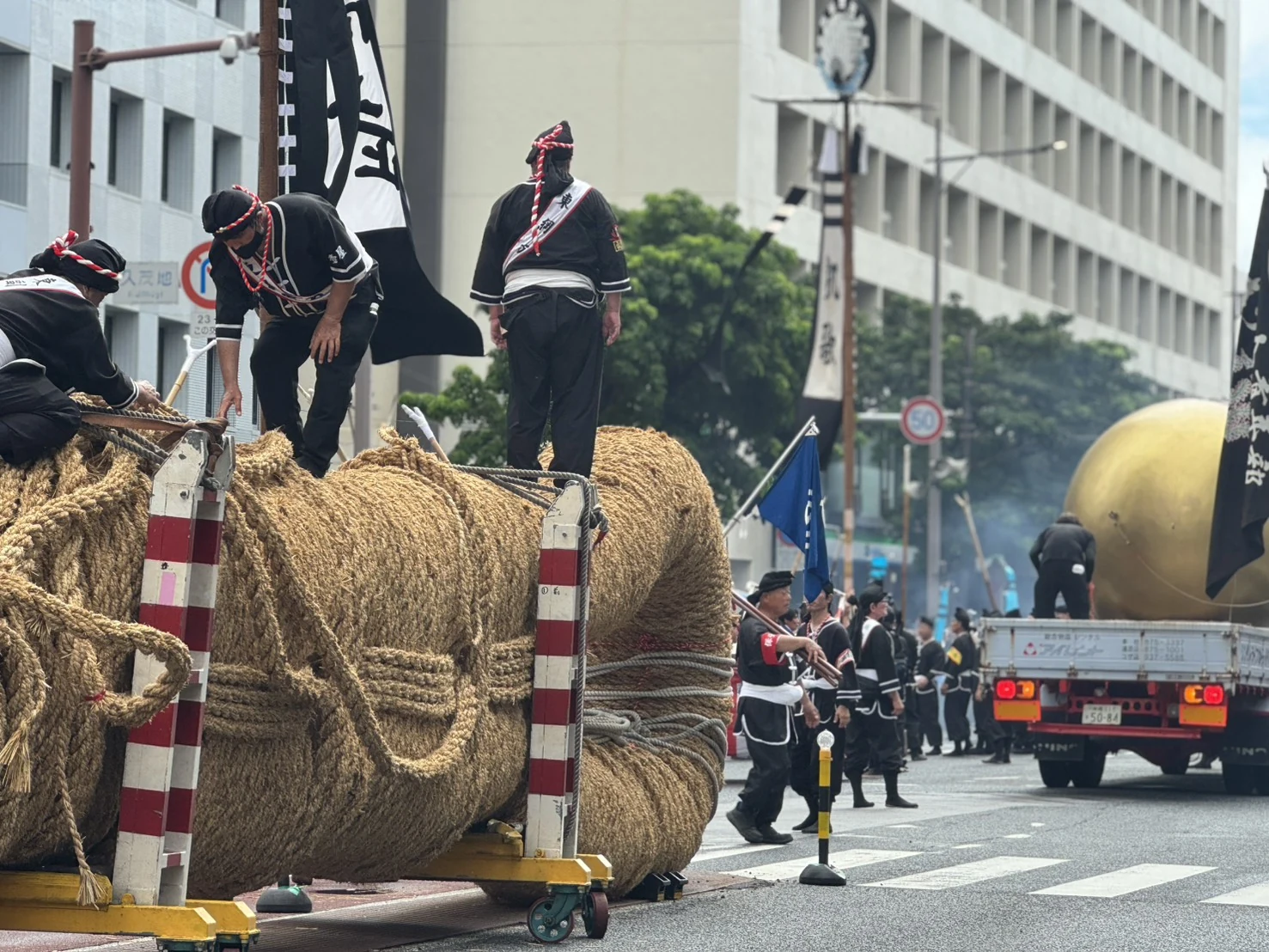 大きな輪を持つ綱の端と、その周囲で準備する人たち